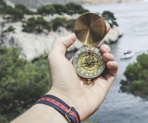 Man's hands holding a compass